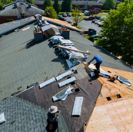 Aerial view of two men working on a home roof repair