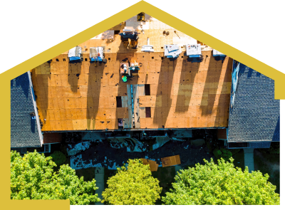 An aerial view of a house under construction with workers performing roof replacement